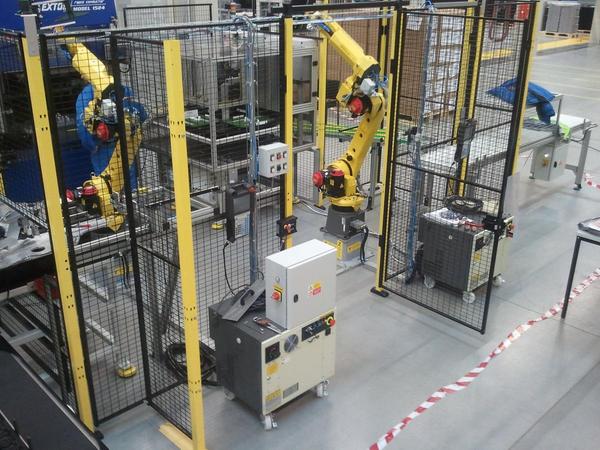 F-Robotické hnízdo Valeo – sestava dvou robotů a dopravníkového systému k broušení rotorů na kompresory do aut, tzn. manipulace do a z brusky